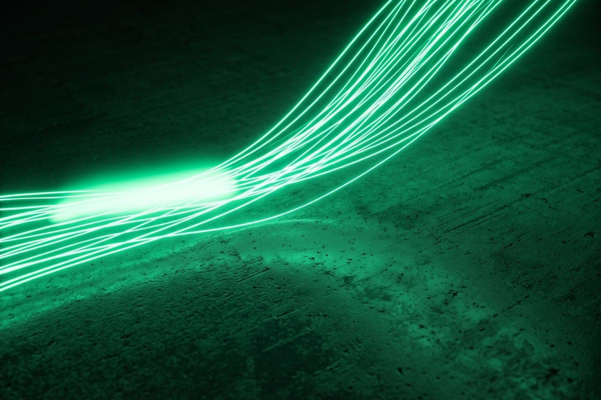 Feixes de luz verde percorrendo uma superfície escura, sugerindo fluxo de dados e energia em rede.